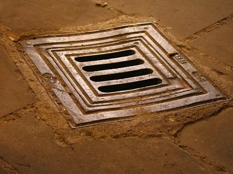 Cast-iron slotted drain grating set in stone paving, Derby DE23