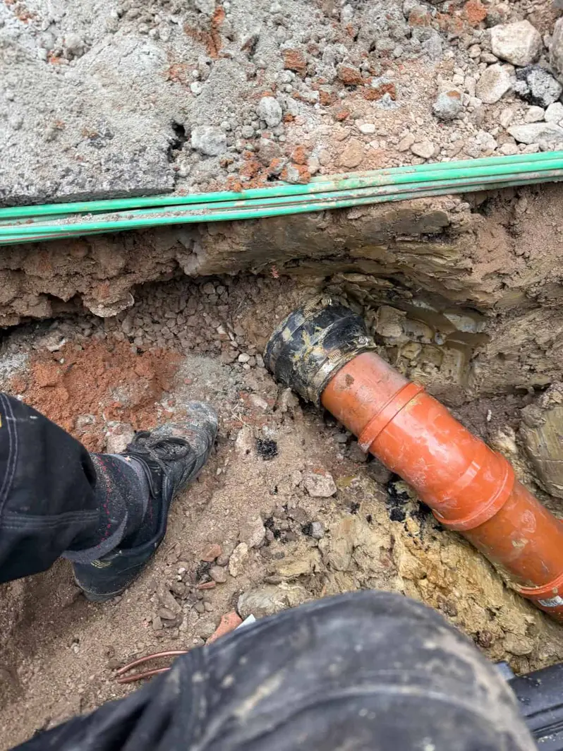 Boot beside an orange pipe joint being fitted in a trench, Allestree DE22