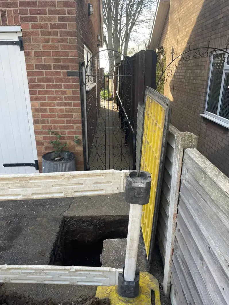 Excavated hole in a driveway behind safety barriers, with no one in shot, Chaddesden DE21