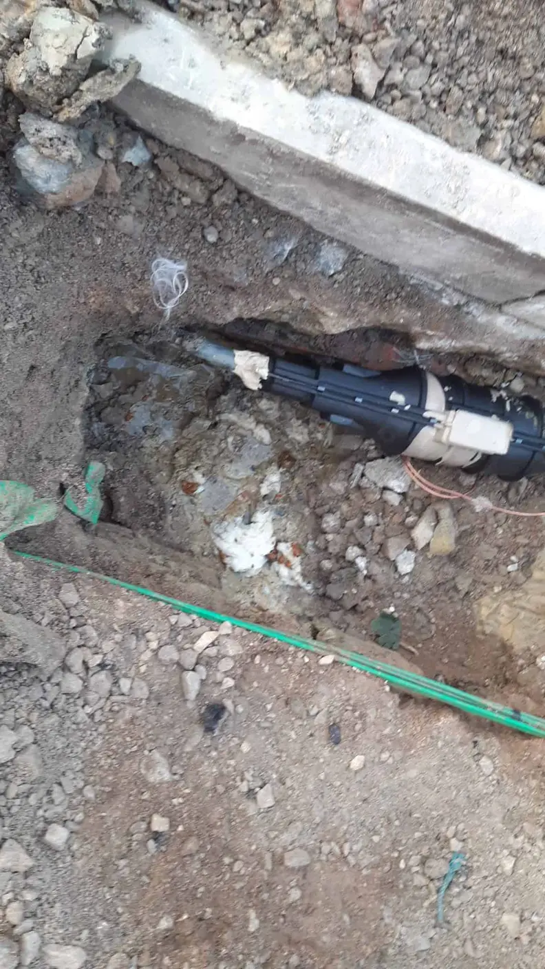 Close-up of a black lining or coupling device set into a pipe run in a trench, Allestree DE22