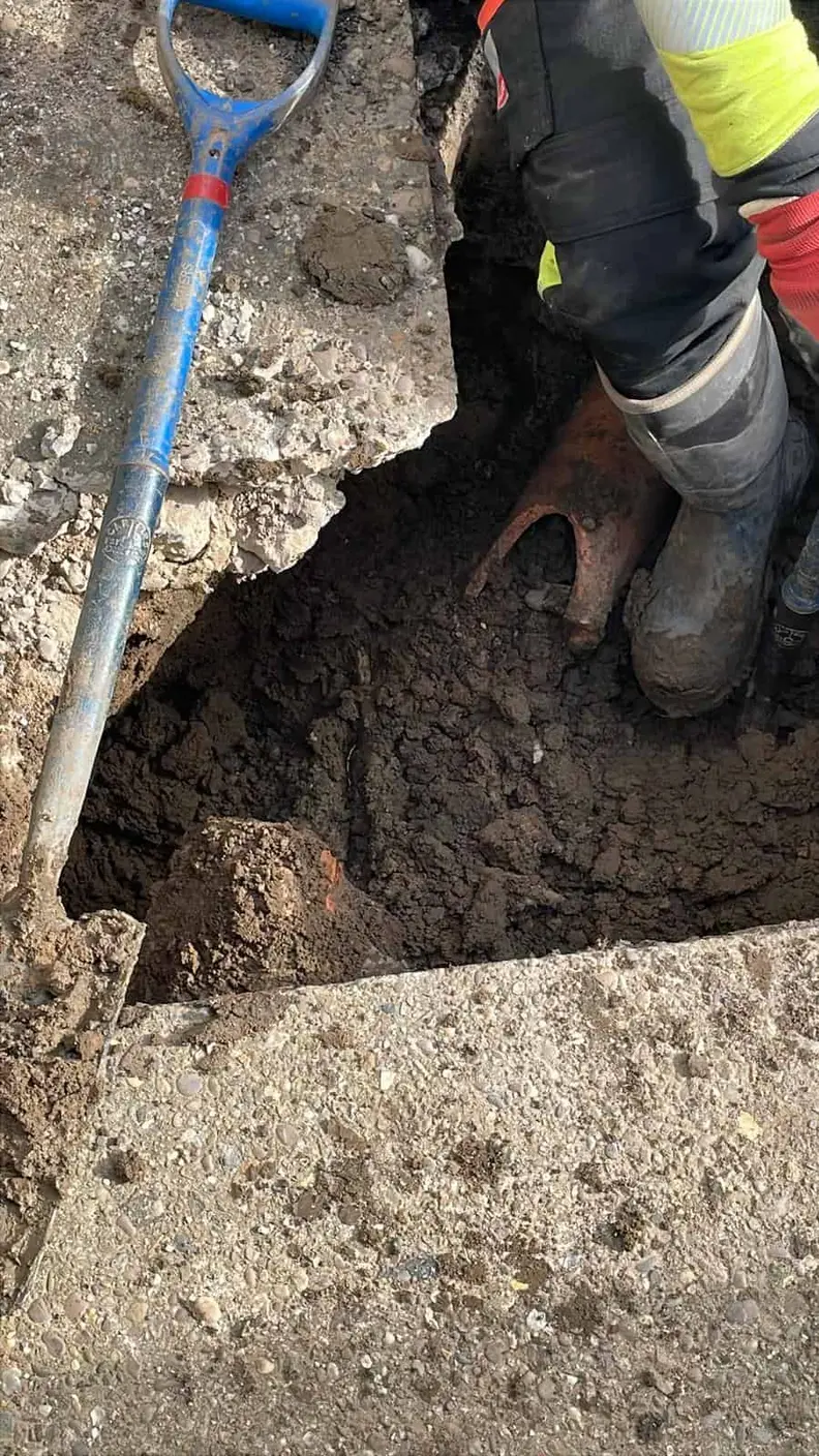 Boot beside a shovel at a hole broken through a concrete slab, Chaddesden DE21
